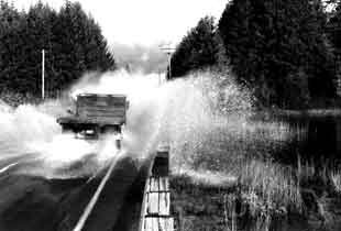 truck driving through flooded water